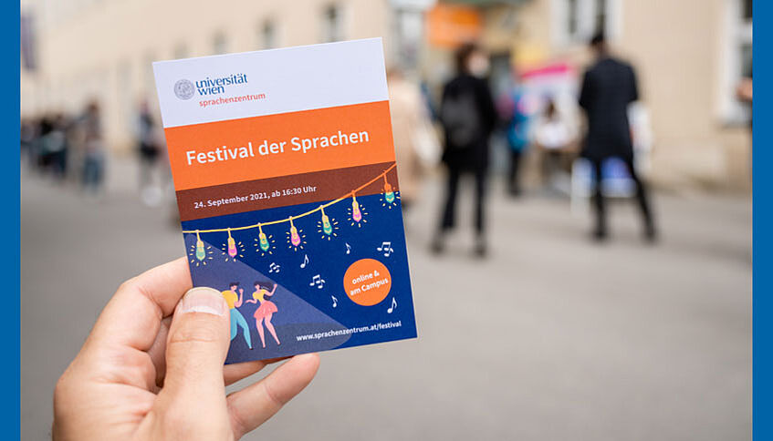 Hand hält Flyer zum Festival der Sprachen